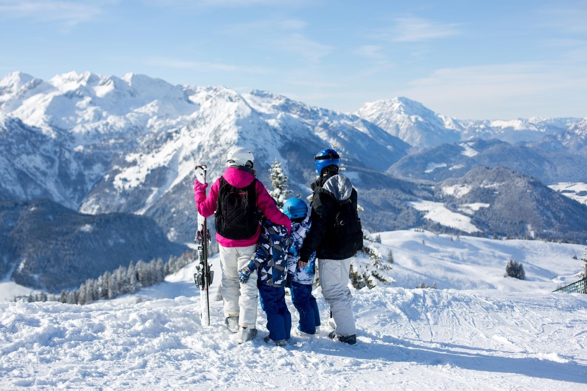 Happy family, mother, father and two children, skiing in Austrian Alps