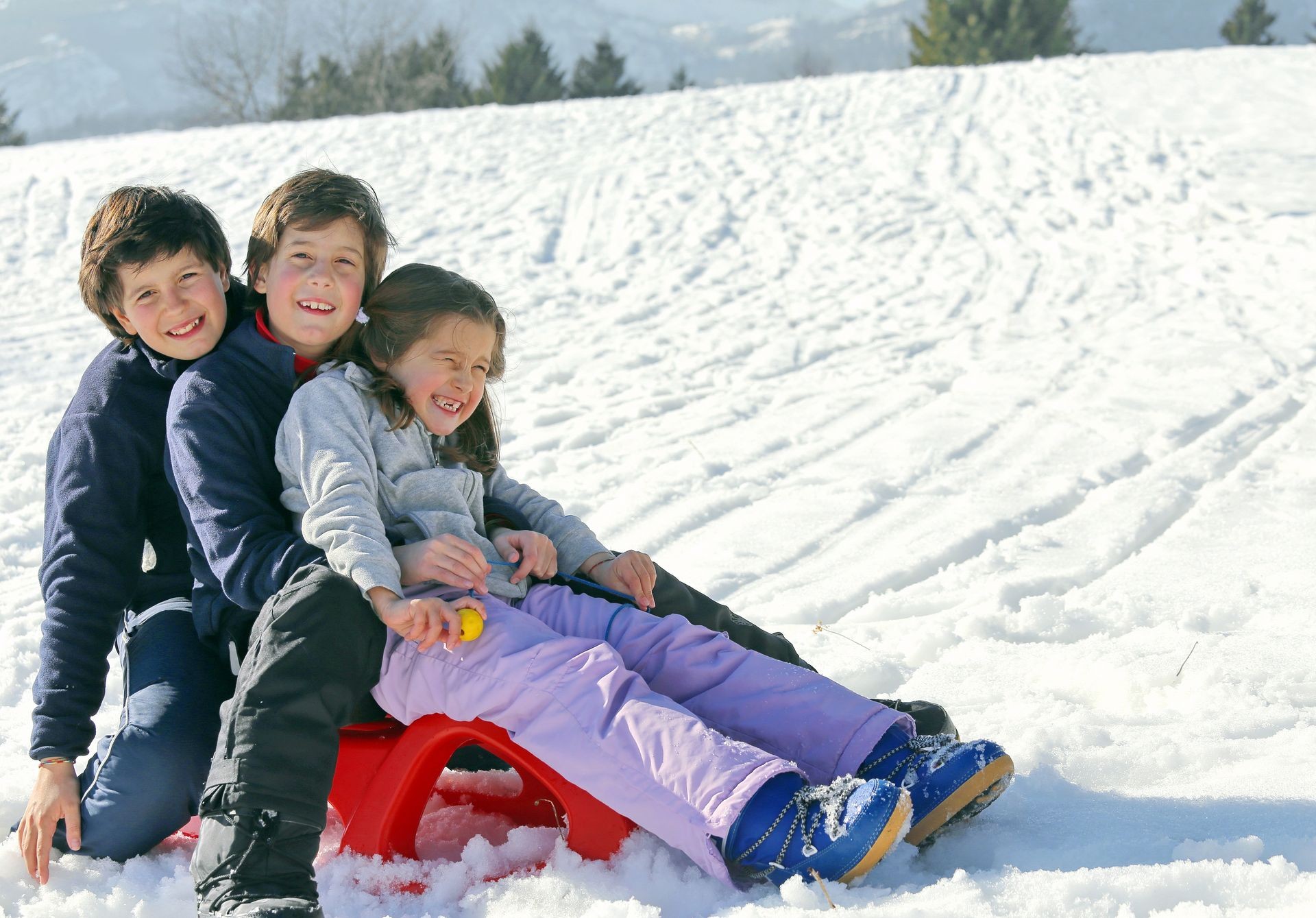 three brothers on the sled in the snow mountain in winter